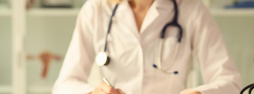 Nahaufnahme einer hölzernen Richterkavel auf einem Tisch weibliche Ärztin, die Papierkram auf dem Hintergrund macht. Rechtsstreitigkeiten, Missbräuche und kriminalistische Konzepte