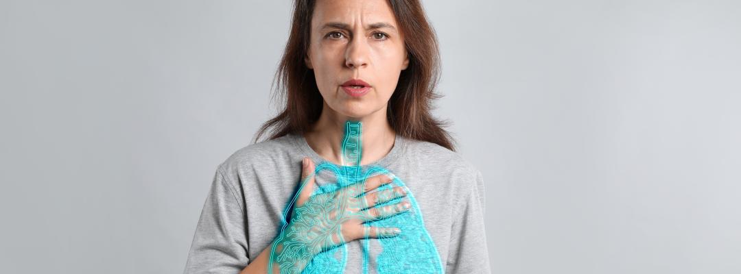 Frau mit Asthma leidet unter Atembeschwerden auf grauem Hintergrund. Lungendarstellung