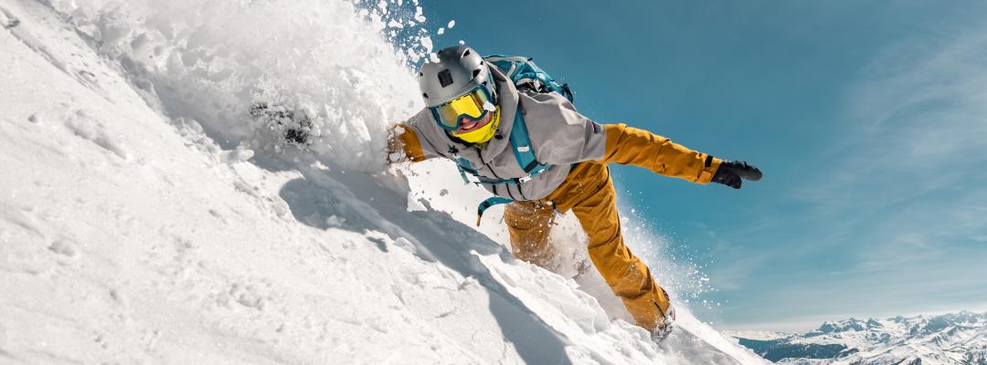 Schneller Mann Snowboarder reitet in Pulverschnee vor der Skipiste. Backcountry oder Freeriden im Skigebiet