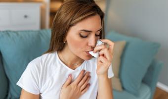 frau benutzt Inhalationsgerät für Asthma