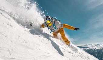 Schneller Mann Snowboarder reitet in Pulverschnee vor der Skipiste. Backcountry oder Freeriden im Skigebiet
